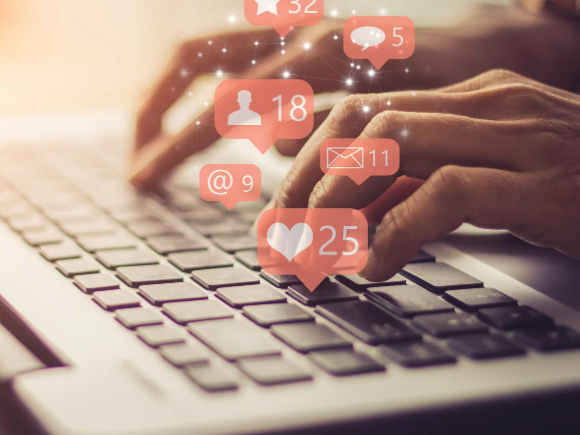 Hands typing with social media notifications